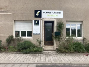 Façade extérieure de l'agence Pompes Funèbres Dolmazon avec enseigne et vitrine.